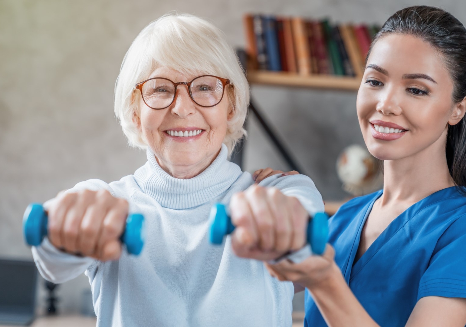 Senior woman training with physiotherapist using dumbbells at home