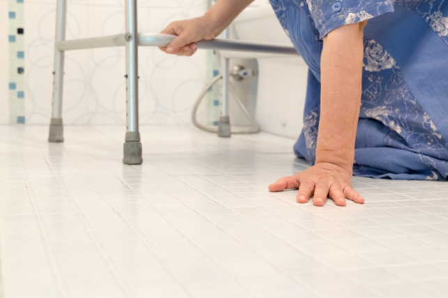 Elderly woman on bathroom floor after falling