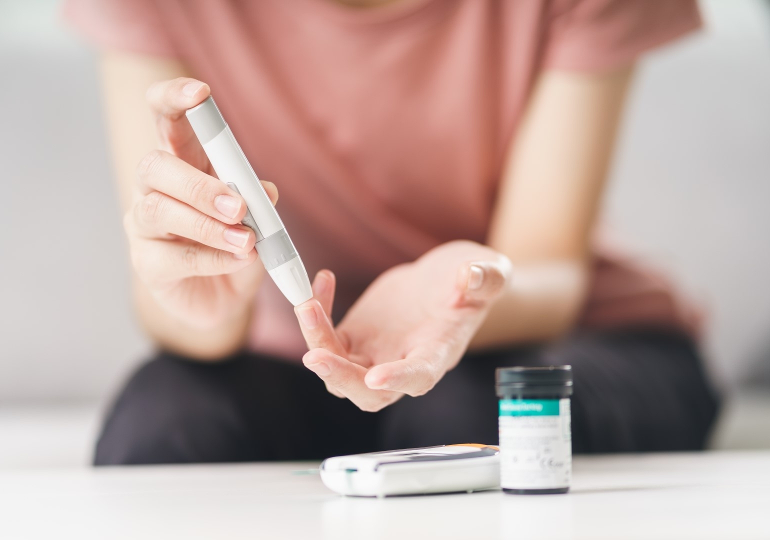 Woman testing her sugar levels with lancet on fingertip