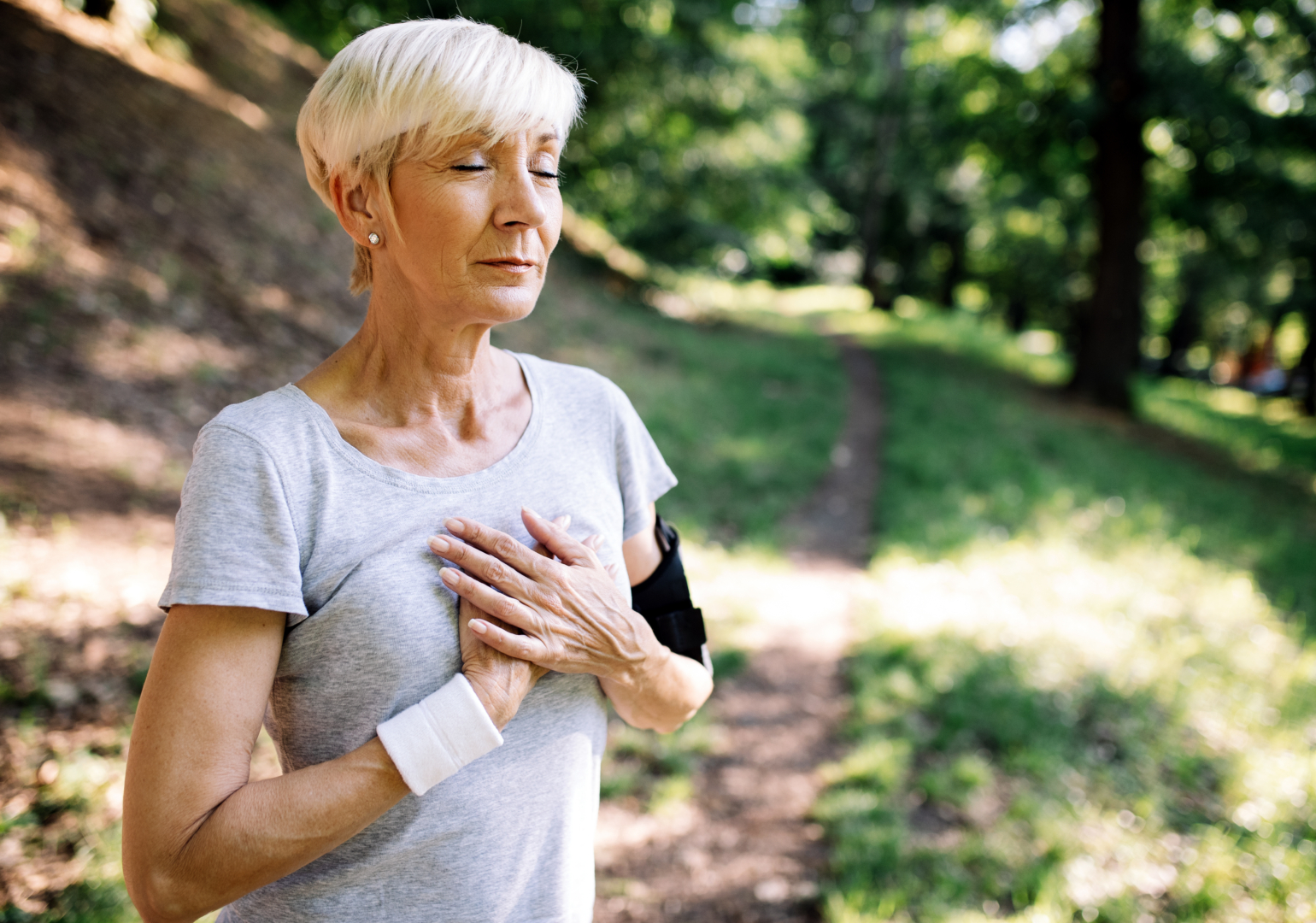 Woman with chest pain suffering from heart attack during running.